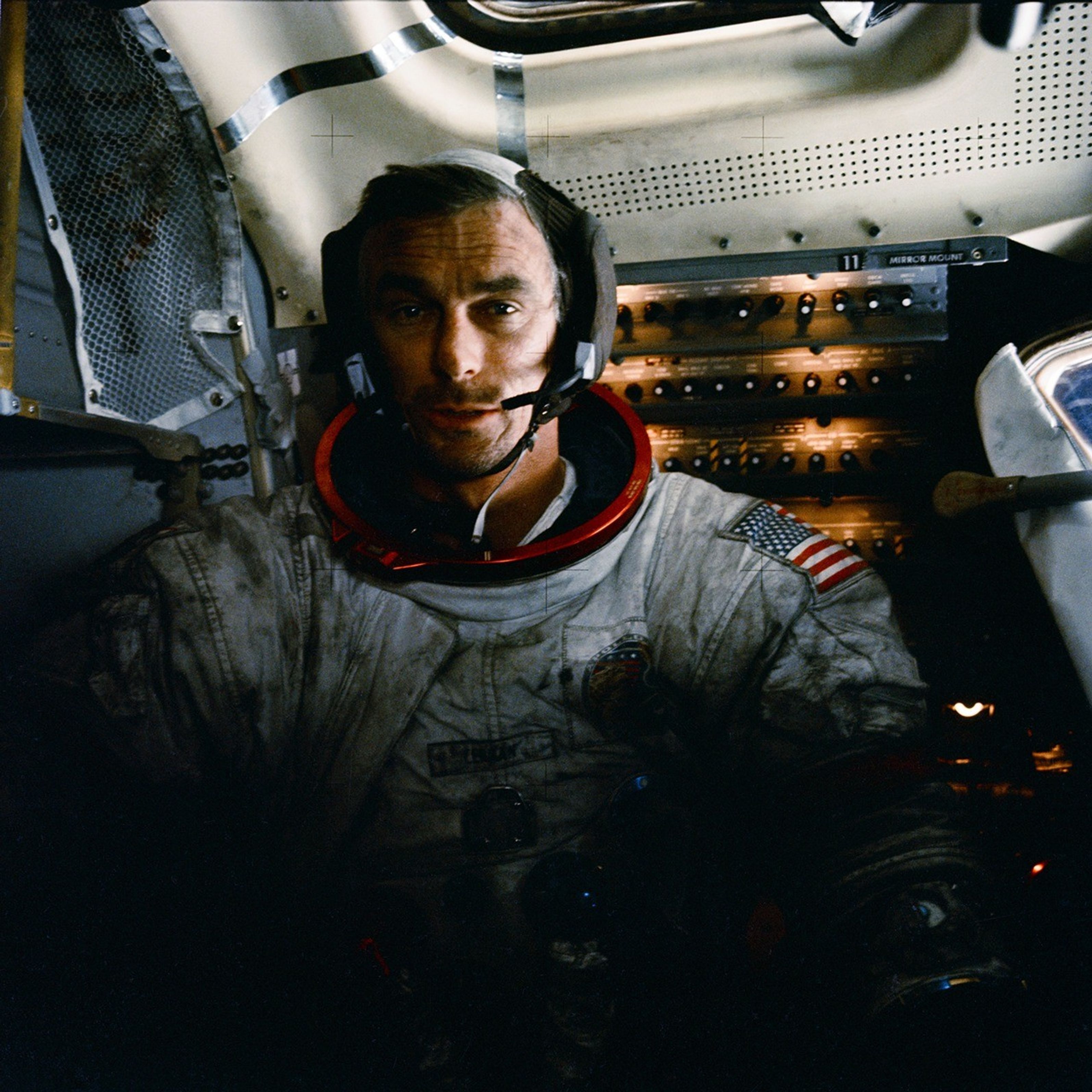 Gene Cernan inside Apollo 17’s lunar module, wearing his dust-covered spacesuit.